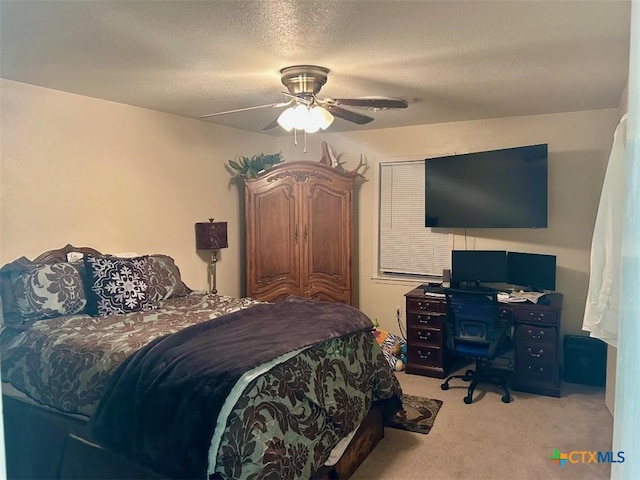 bedroom with a ceiling fan, a textured ceiling, and light colored carpet