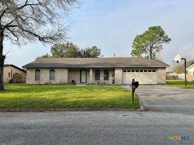 ranch-style home with brick siding, central AC, a garage, driveway, and a front lawn