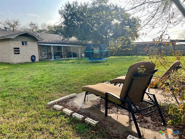 view of yard featuring a trampoline, a patio area, and a fenced backyard