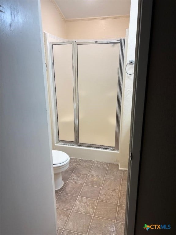 full bath featuring a stall shower, toilet, and tile patterned floors