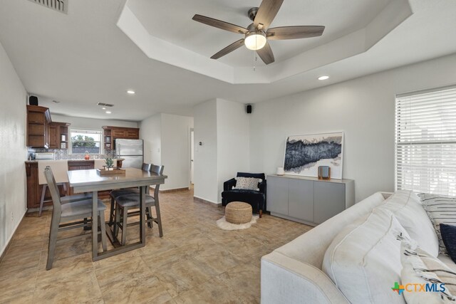 dining room featuring ceiling fan and a tray ceiling