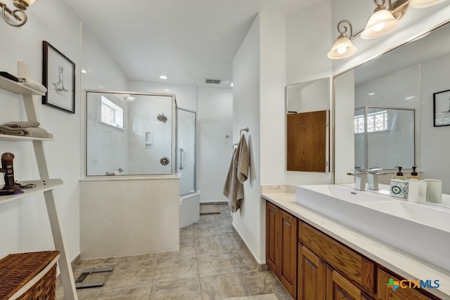 bathroom featuring walk in shower, a wealth of natural light, and vanity