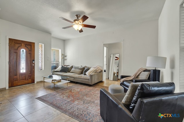 tiled living room featuring a textured ceiling and ceiling fan