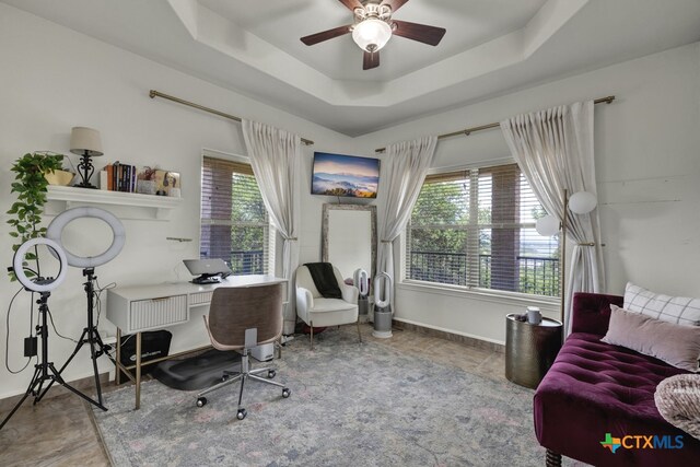 office with ceiling fan and a raised ceiling