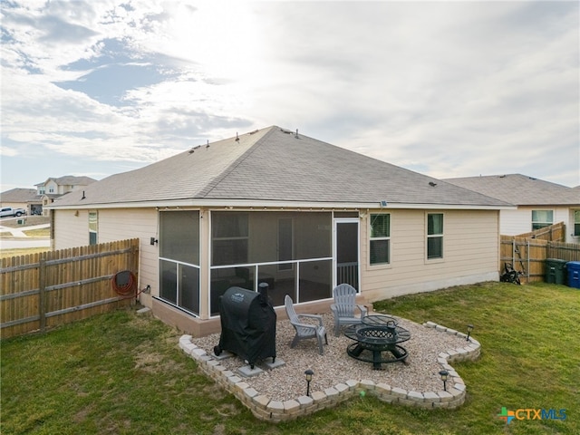 rear view of house with an outdoor fire pit, a lawn, a sunroom, a fenced backyard, and roof with shingles