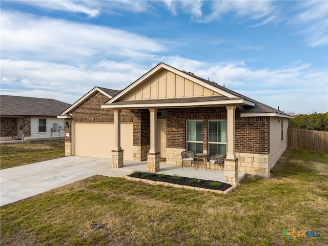 craftsman inspired home featuring board and batten siding, a front yard, concrete driveway, and a garage