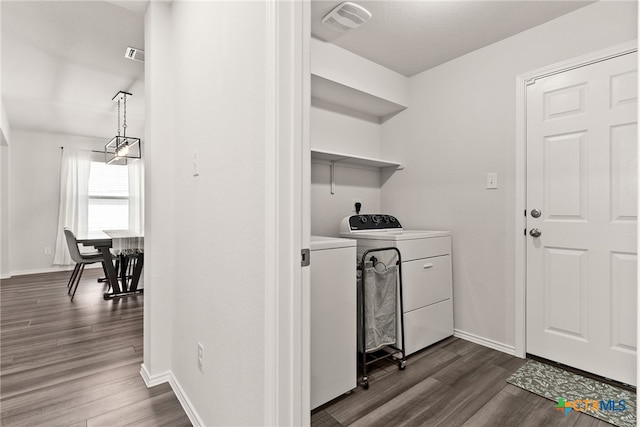 laundry area featuring washing machine and dryer, laundry area, visible vents, baseboards, and dark wood finished floors