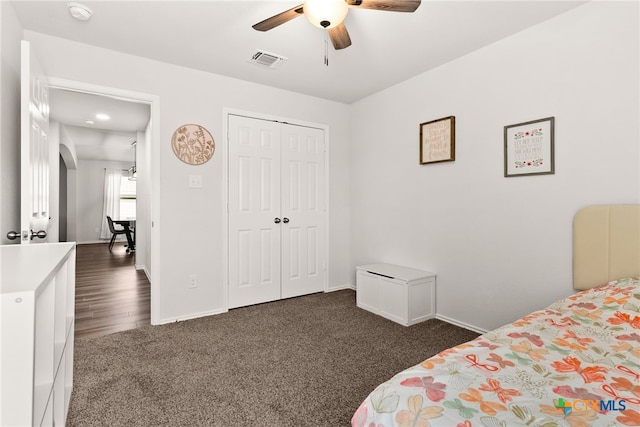 carpeted bedroom with a ceiling fan, a closet, visible vents, and baseboards