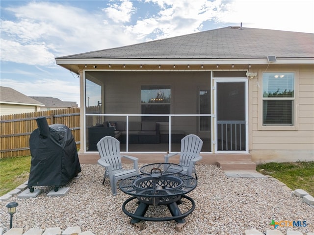 back of property featuring an outdoor fire pit, a patio area, fence, and roof with shingles