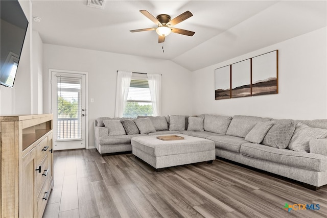 living area with lofted ceiling, visible vents, ceiling fan, wood finished floors, and baseboards