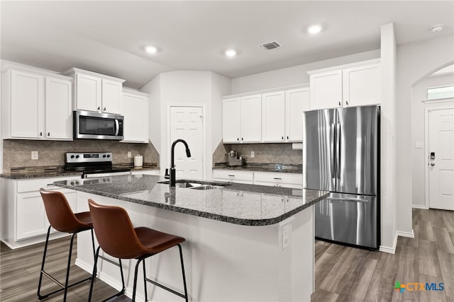 kitchen featuring visible vents, white cabinets, dark wood finished floors, appliances with stainless steel finishes, and a sink