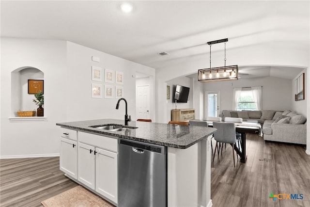 kitchen with dark wood finished floors, stainless steel dishwasher, white cabinets, a sink, and dark stone countertops