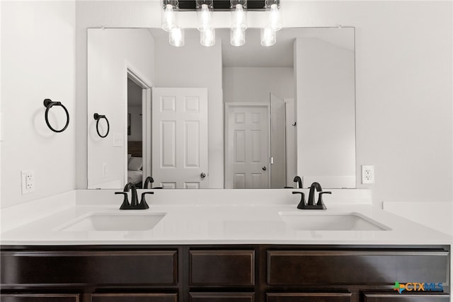 full bathroom featuring double vanity, a sink, and ensuite bathroom