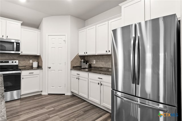 kitchen with appliances with stainless steel finishes, tasteful backsplash, white cabinets, and wood finished floors