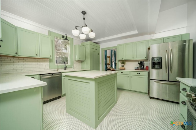 kitchen with a tray ceiling, appliances with stainless steel finishes, green cabinets, an inviting chandelier, and light countertops