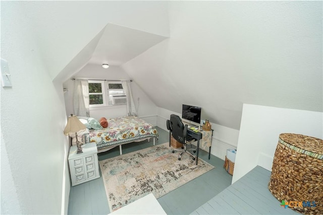 bedroom featuring cooling unit, wood finished floors, and vaulted ceiling