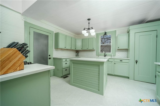 laundry room featuring a sink, crown molding, light floors, and a chandelier