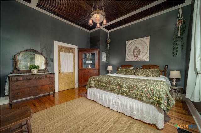 bedroom with ornamental molding, wooden ceiling, baseboards, and wood finished floors