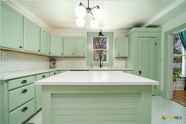 kitchen featuring a chandelier, backsplash, light countertops, and a sink