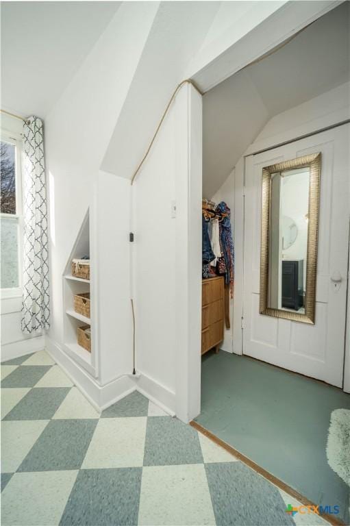 bonus room with tile patterned floors, baseboards, and lofted ceiling