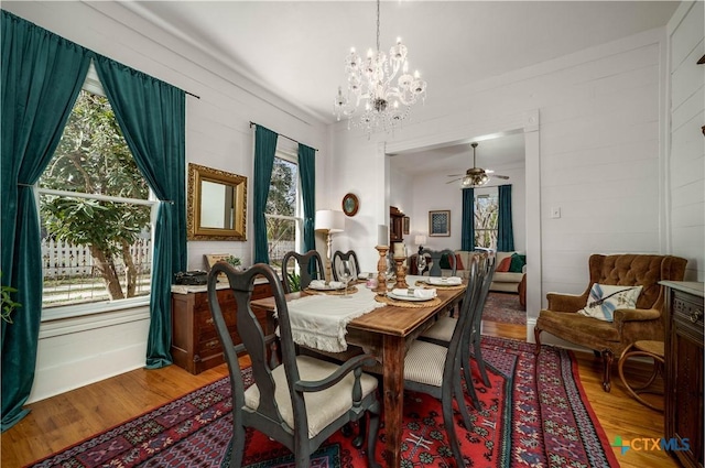 dining room featuring ceiling fan with notable chandelier and wood finished floors