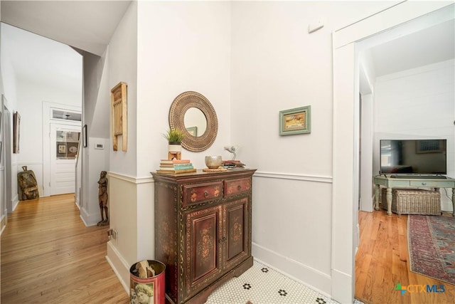 hall featuring baseboards and light wood-style flooring