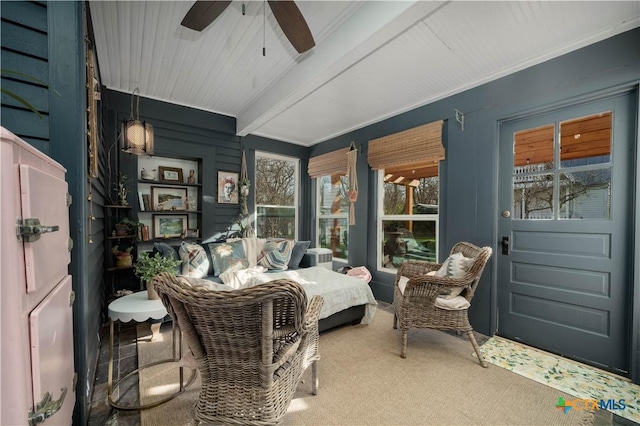 sunroom featuring beam ceiling and a ceiling fan