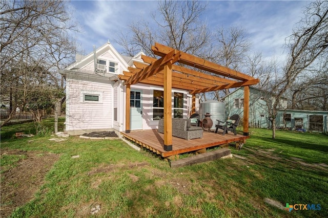 back of property featuring a yard, a wooden deck, and a pergola