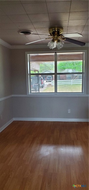 spare room with a drop ceiling, hardwood / wood-style flooring, and ceiling fan