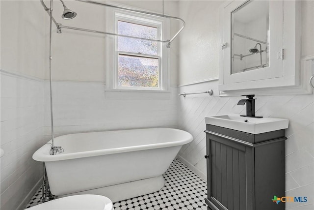 610 N 7th St, Temple, TX 76501 - bathroom featuring vanity, a soaking tub, tile walls, a wainscoted wall, and tile patterned flooring