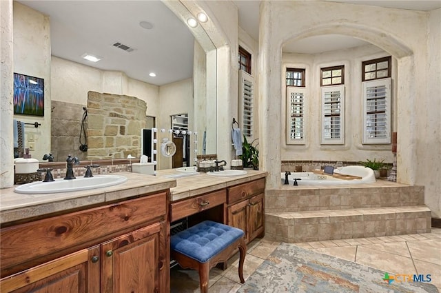 105 Flint Ridge Trl, Georgetown, TX 78628 - bathroom featuring a garden tub, vanity, tile patterned flooring, and tiled shower