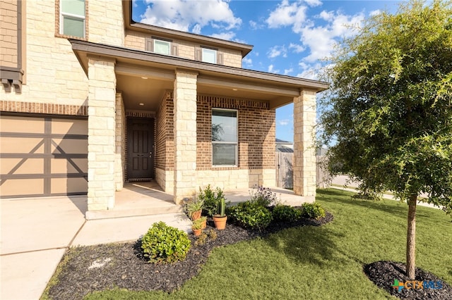 property entrance featuring a yard, brick siding, and stone siding