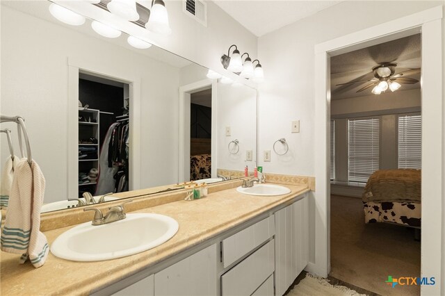 402 Teakwood Dr, Victoria, TX 77901 - bathroom with double vanity, ensuite bathroom, a walk in closet, and a ceiling fan