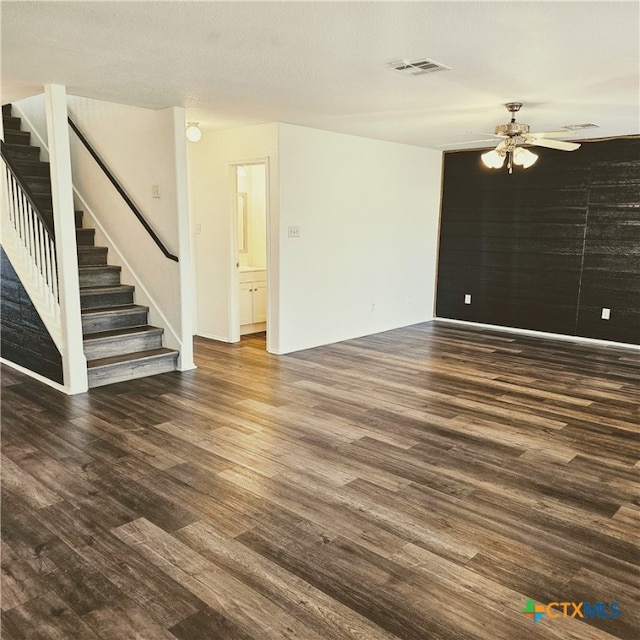 unfurnished living room featuring ceiling fan, dark hardwood / wood-style floors, and a textured ceiling