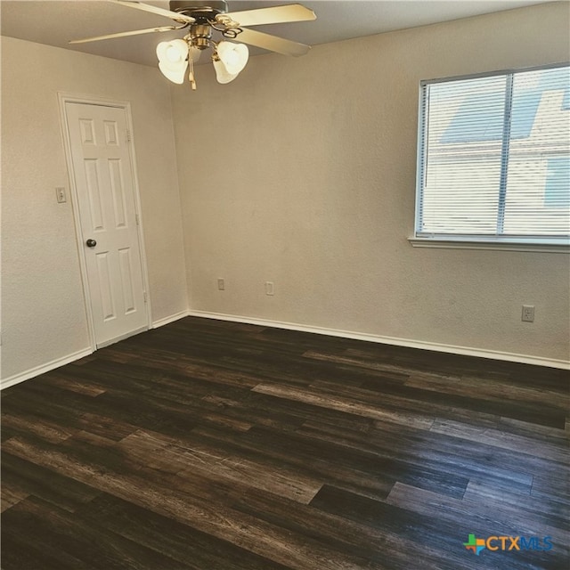 empty room with dark hardwood / wood-style floors and ceiling fan