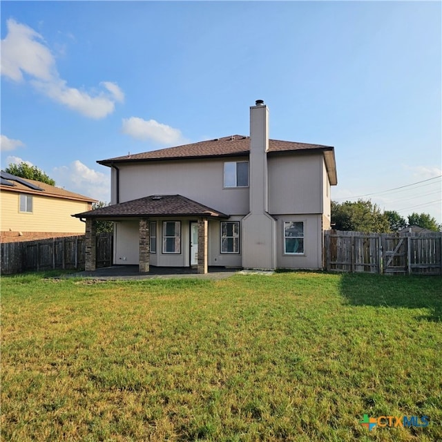 rear view of house with a yard and a patio area