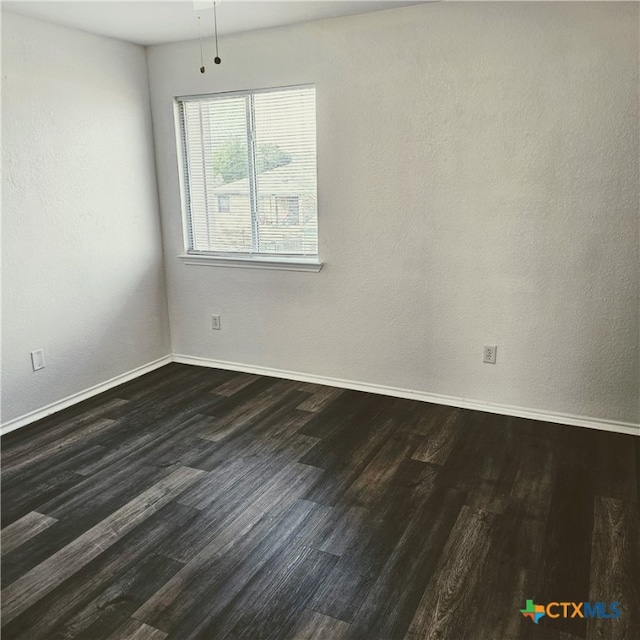 spare room featuring dark wood-type flooring