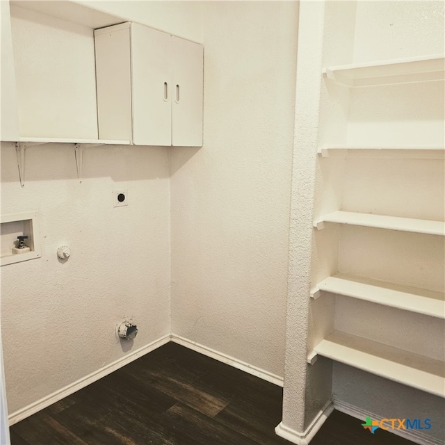 laundry area featuring cabinets, dark hardwood / wood-style flooring, electric dryer hookup, and gas dryer hookup