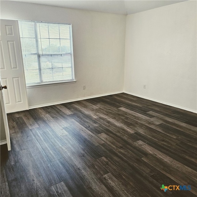 unfurnished room featuring dark wood-type flooring