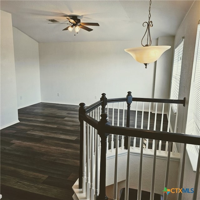 stairs with hardwood / wood-style flooring and ceiling fan