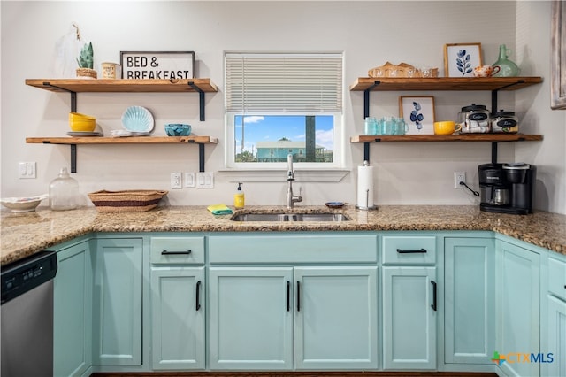 kitchen with blue cabinetry, stainless steel dishwasher, sink, and light stone counters