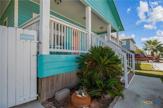 view of side of home featuring covered porch