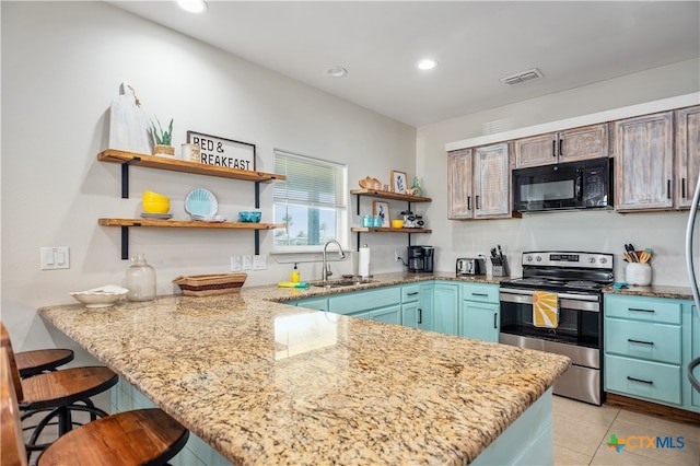 kitchen with a kitchen bar, kitchen peninsula, sink, and stainless steel range with electric stovetop