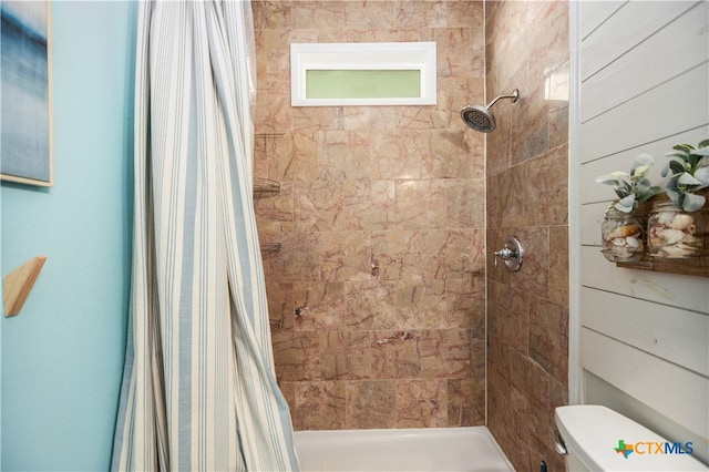 bathroom with a shower with shower curtain and toilet