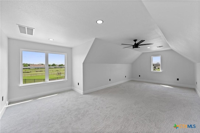 bonus room with visible vents, baseboards, vaulted ceiling, and light carpet