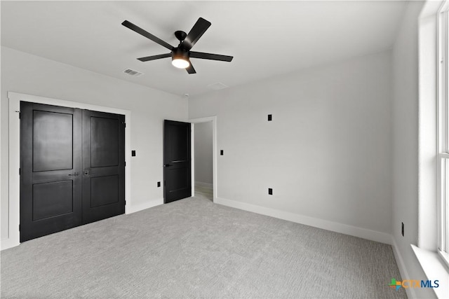 unfurnished bedroom with carpet floors, baseboards, ceiling fan, and visible vents