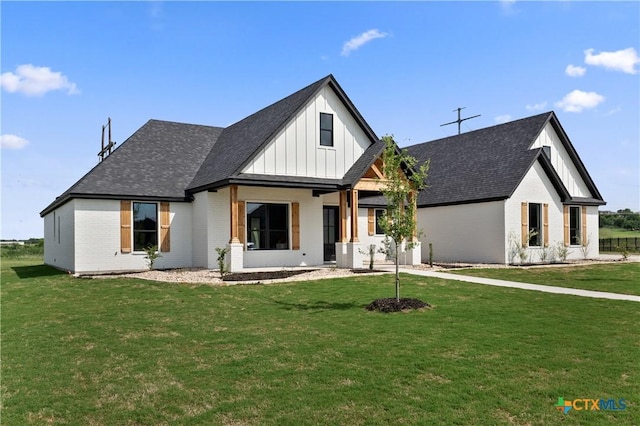 modern farmhouse style home with board and batten siding, brick siding, and a front yard