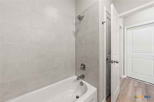 bathroom featuring hardwood / wood-style flooring and tiled shower / bath