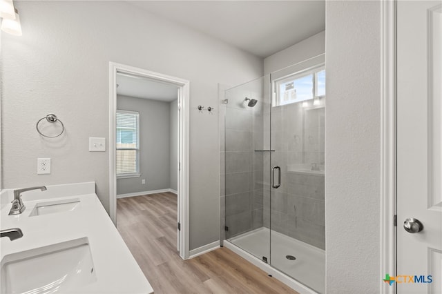 bathroom with vanity, an enclosed shower, hardwood / wood-style flooring, and plenty of natural light