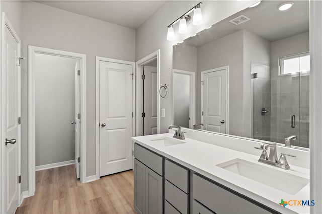 bathroom featuring vanity, an enclosed shower, and wood-type flooring